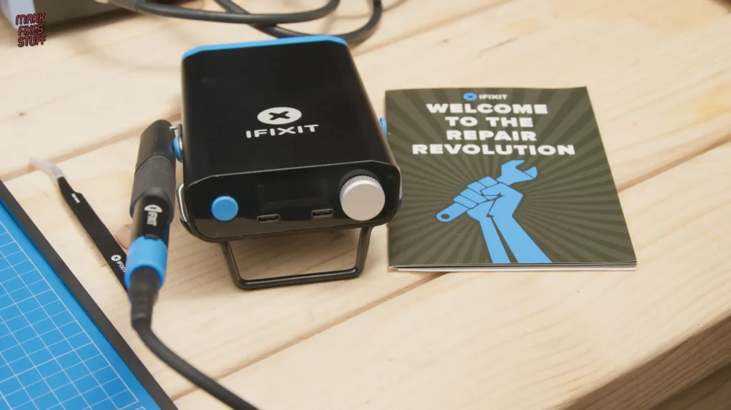 iFixit soldering station and tools on workbench with welcome to the repair revolution booklet