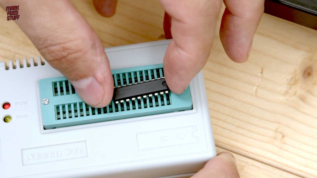 DIP logic chip seated in the ZIF socket of an XGecu Pro programmer for testing