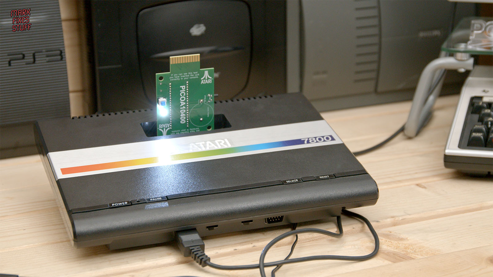 Bare Pico A10400 circuit board installed in an Atari 7800 with its white LED illuminated